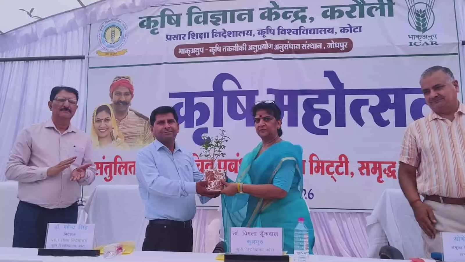 करौली में ग्राम कृषि महोत्सव के दौरान मंच पर पौधा भेंट करते डॉक्टर बी एस मीणा और कुलगुरु विमला डुंकवाल करौली में ग्राम कृषि महोत्सव के दौरान मंच पर पौधा भेंट करते डॉक्टर बी एस मीणा और कुलगुरु विमला डुंकवाल