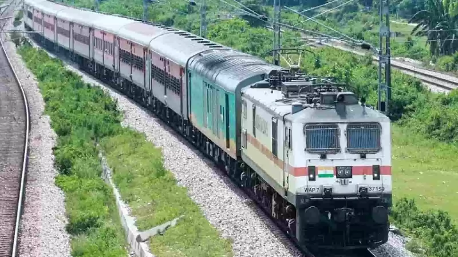 हरे-भरे मैदानों के बीच रेलवे ट्रैक पर मुड़ती हुई भारतीय रेलवे की एक पैसेंजर ट्रेन। हरे-भरे मैदानों के बीच रेलवे ट्रैक पर मुड़ती हुई भारतीय रेलवे की एक पैसेंजर ट्रेन।