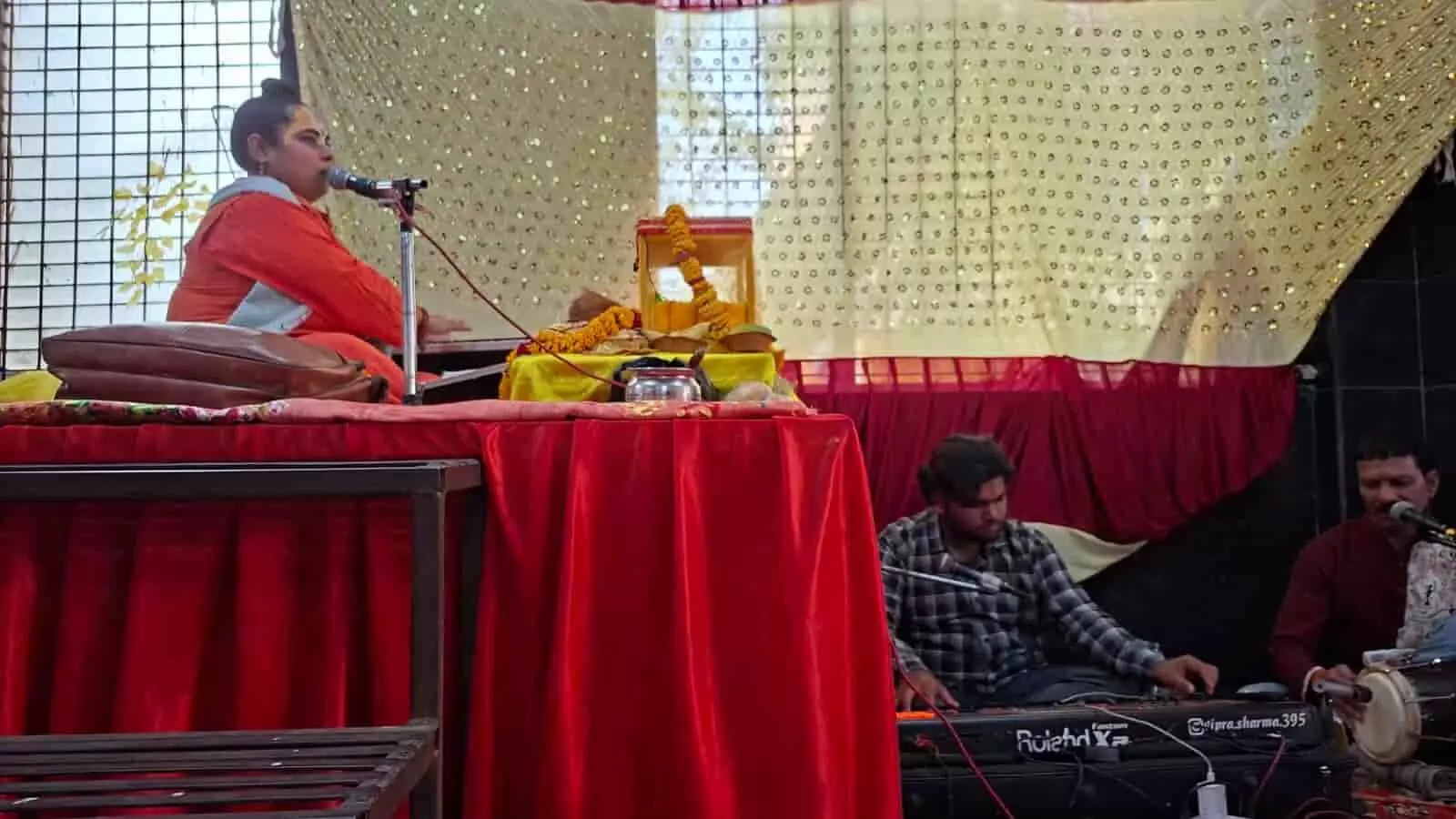 महावीर नगर में नानी बाई का मायरा कथा महोत्सव के मंच पर बैठकर माइक के सामने कथा सुनातीं बाल साध्वी आरती किशोरी दास और नीचे वाद्य यंत्र बजाते संगीतकार। महावीर नगर में नानी बाई का मायरा कथा महोत्सव के मंच पर बैठकर माइक के सामने कथा सुनातीं बाल साध्वी आरती किशोरी दास और नीचे वाद्य यंत्र बजाते संगीतकार।
