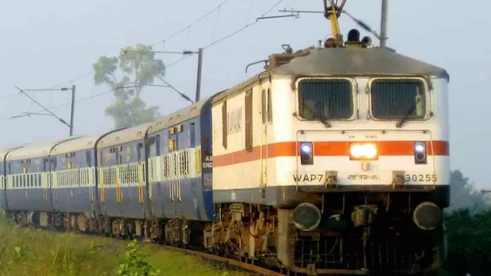 भारतीय रेलवे की पटरी पर दौड़ती हुई एक सफेद और लाल रंग की इलेक्ट्रिक ट्रेन इंजन भारतीय रेलवे की पटरी पर दौड़ती हुई एक सफेद और लाल रंग की इलेक्ट्रिक ट्रेन इंजन