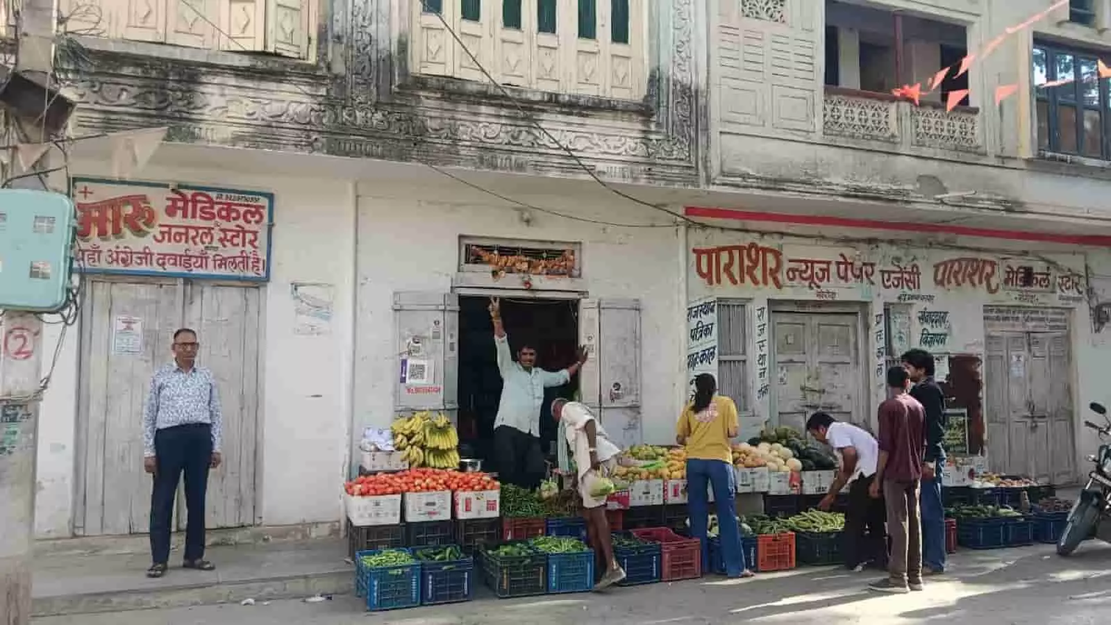 खेरोदा में ऑनलाइन दवा बिक्री के विरोध में बंद मेडिकल स्टोर के बाहर खड़े लोग और फल-सब्जी विक्रेता।