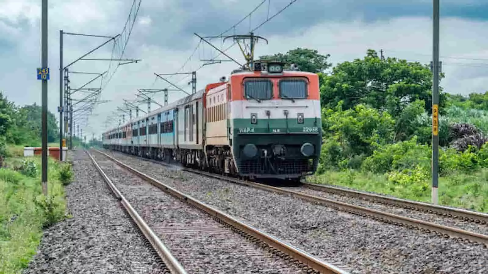 रेलवे ट्रैक पर दौड़ती हुई भारतीय रेलवे की एक इलेक्ट्रिक सुपरफास्ट पैसेंजर ट्रेन।