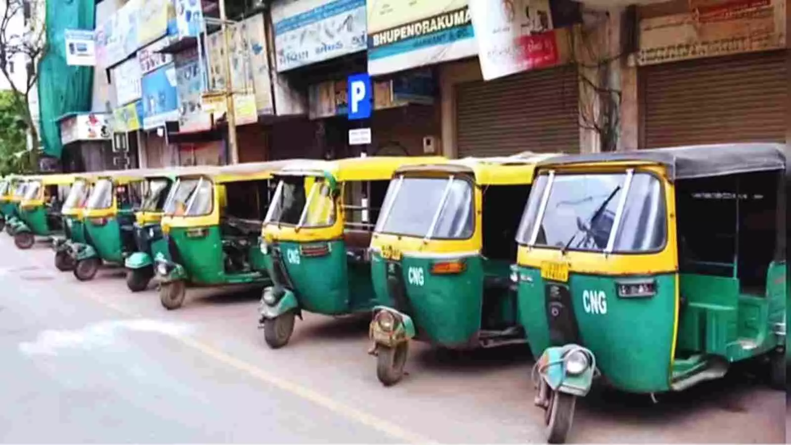 सड़क किनारे कतार में खड़े हरे और पीले रंग के ऑटो रिक्शा दिल्ली में हड़ताल के दौरान खाली पड़े हैं। सड़क किनारे कतार में खड़े हरे और पीले रंग के ऑटो रिक्शा दिल्ली में हड़ताल के दौरान खाली पड़े हैं।