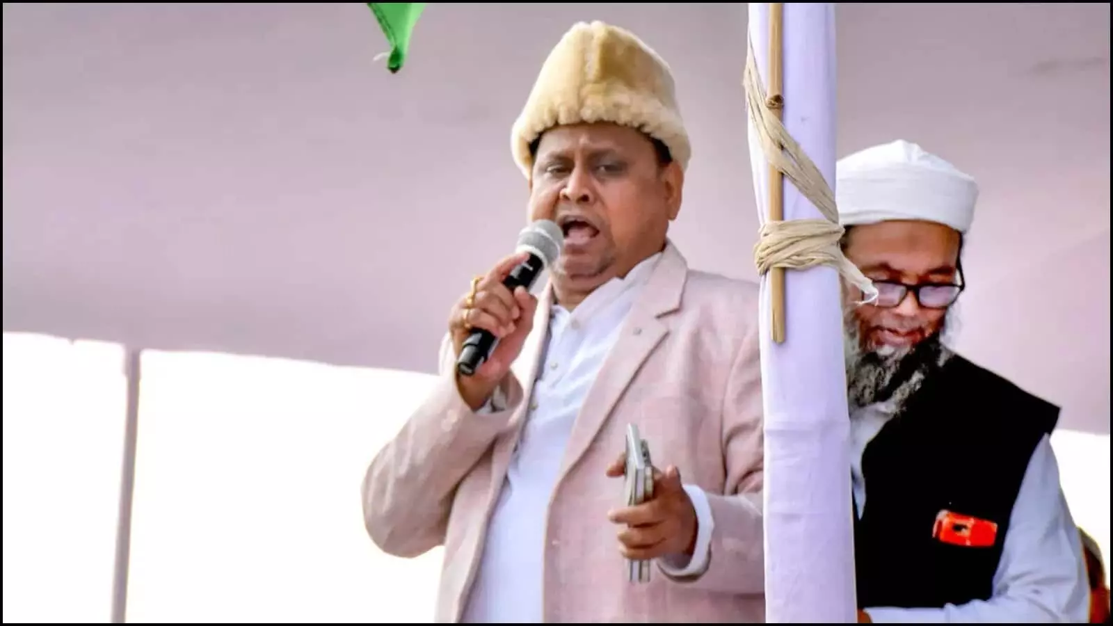 जनसभा के मंच पर हाथ में माइक थामकर भाषण देते हुए हुमायूं कबीर और उनके पीछे खड़े एक अन्य व्यक्ति। जनसभा के मंच पर हाथ में माइक थामकर भाषण देते हुए हुमायूं कबीर और उनके पीछे खड़े एक अन्य व्यक्ति।