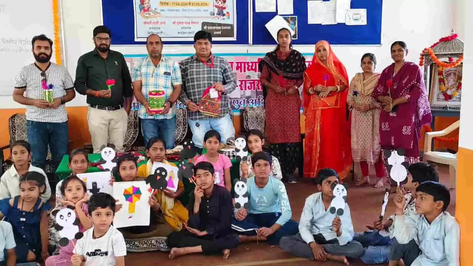 आमेट के स्कूल में कला प्रदर्शनी के दौरान हाथ में पेपर पांडा और चित्रकला थामे बच्चे तथा शिक्षक। आमेट के स्कूल में कला प्रदर्शनी के दौरान हाथ में पेपर पांडा और चित्रकला थामे बच्चे तथा शिक्षक।
