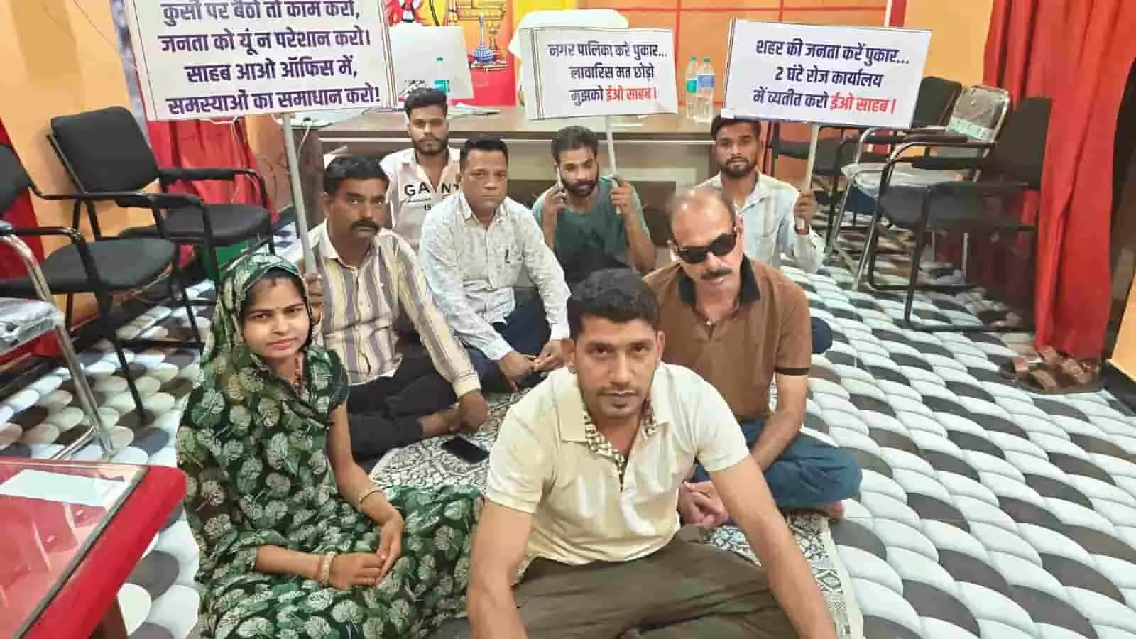 झालेरापाटन नगर पालिका कार्यालय के भीतर तख्तियां लेकर जमीन पर धरने पर बैठे महिला और पुरुष कांग्रेस कार्यकर्ता। झालेरापाटन नगर पालिका कार्यालय के भीतर तख्तियां लेकर जमीन पर धरने पर बैठे महिला और पुरुष कांग्रेस कार्यकर्ता।