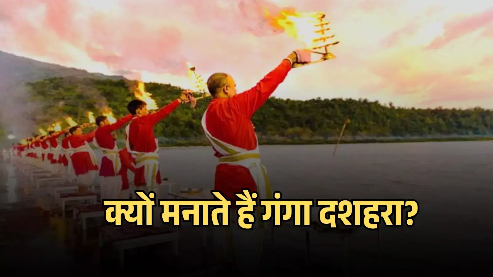 नदी किनारे खड़े होकर पीत वस्त्र पहने पुजारी हाथ में जलती हुई बड़ी आरती उठाए गंगा आरती कर रहे हैं। नदी किनारे खड़े होकर पीत वस्त्र पहने पुजारी हाथ में जलती हुई बड़ी आरती उठाए गंगा आरती कर रहे हैं।