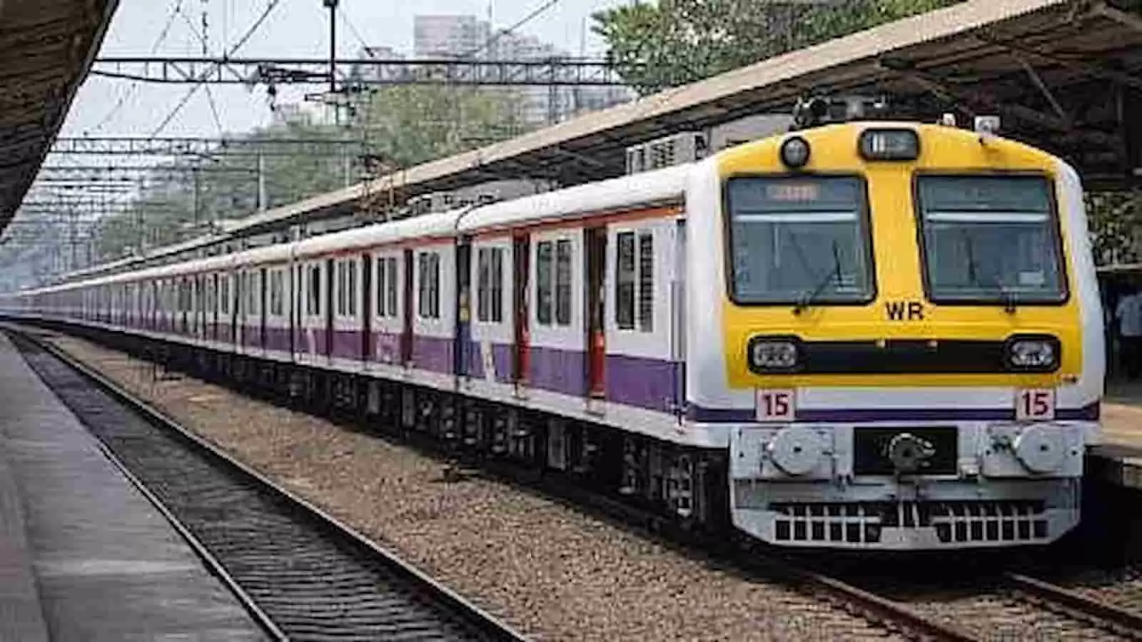 प्लेटफॉर्म के पास पटरी पर चलती हुई पीले और सफेद रंग की मुंबई लोकल ट्रेन। प्लेटफॉर्म के पास पटरी पर चलती हुई पीले और सफेद रंग की मुंबई लोकल ट्रेन।