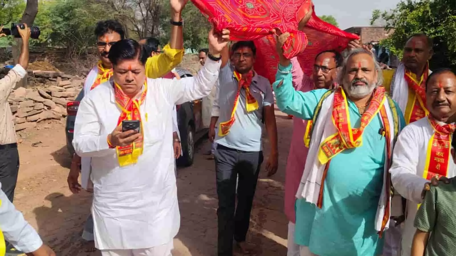 गंगापुर सिटी में बिजासन खोहरी माता मंदिर की चुनरी यात्रा में लाल रंग की चुनरी पकड़े हुए श्रद्धालु और पुरुषोत्तम मास उत्सव। गंगापुर सिटी में बिजासन खोहरी माता मंदिर की चुनरी यात्रा में लाल रंग की चुनरी पकड़े हुए श्रद्धालु और पुरुषोत्तम मास उत्सव।