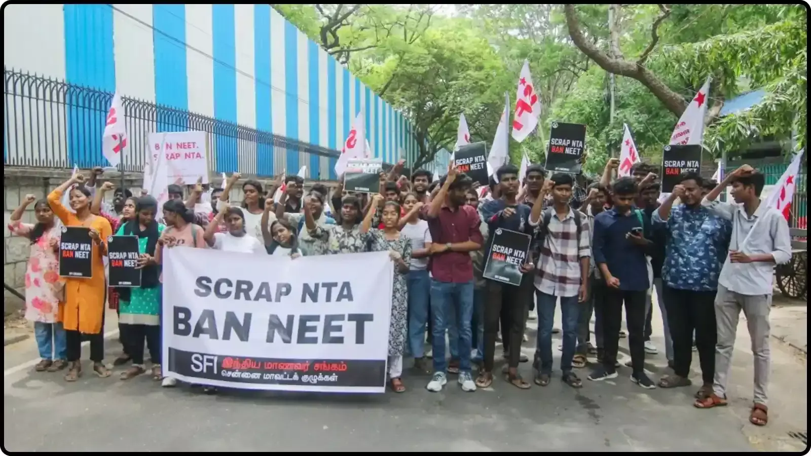 सड़क पर बैनर और झंडे लेकर खड़े छात्र एनटीए के खिलाफ विरोध प्रदर्शन करते हुए। सड़क पर बैनर और झंडे लेकर खड़े छात्र एनटीए के खिलाफ विरोध प्रदर्शन करते हुए।