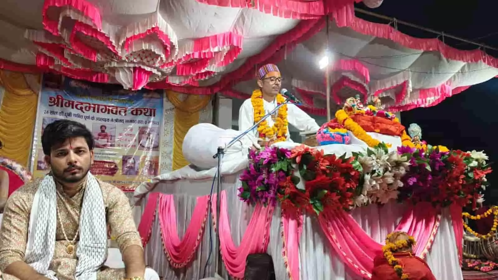 हनुमान मंदिर के मंच पर फूलों से सजी व्यासपीठ से माइक पर श्रीमद्भागवत कथा सुनाते संत युवराज कृष्ण महाराज। हनुमान मंदिर के मंच पर फूलों से सजी व्यासपीठ से माइक पर श्रीमद्भागवत कथा सुनाते संत युवराज कृष्ण महाराज।