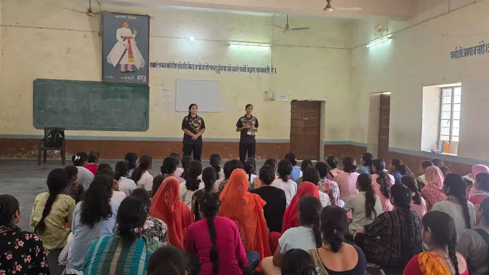 चित्तौड़गढ़ के प्रशिक्षण कक्ष में दरी पर बैठी छात्राओं को मंच से आत्मरक्षा के गुर सिखातीं दो महिला प्रशिक्षक। चित्तौड़गढ़ के प्रशिक्षण कक्ष में दरी पर बैठी छात्राओं को मंच से आत्मरक्षा के गुर सिखातीं दो महिला प्रशिक्षक।