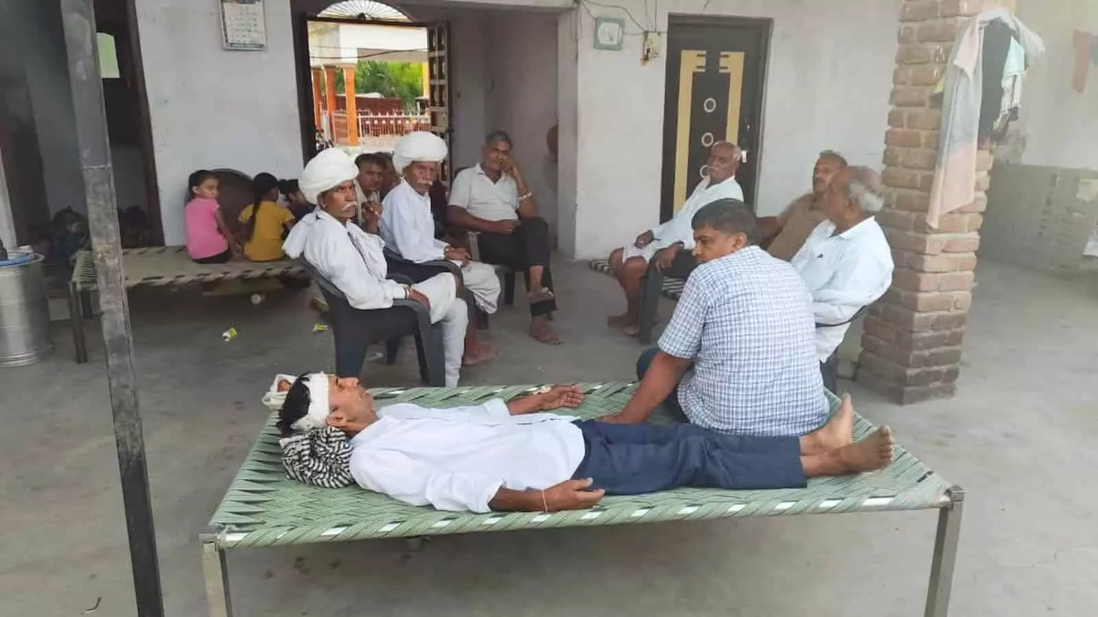 लदानी गाँव में चोरी के दौरान घायल मांगी लाल डांगी खाट पर लेटे हुए और आसपास ग्रामीण बैठे हैं। लदानी गाँव में चोरी के दौरान घायल मांगी लाल डांगी खाट पर लेटे हुए और आसपास ग्रामीण बैठे हैं।