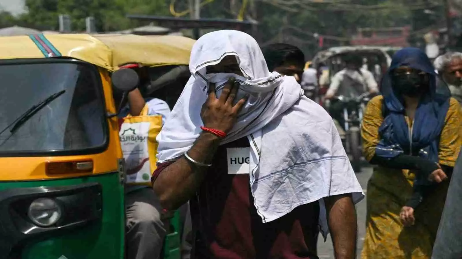 भीषण गर्मी में चेहरे पर सफेद कपड़ा लपेटे हुए एक व्यक्ति दिल्ली की सड़क पर चलता हुआ। भीषण गर्मी में चेहरे पर सफेद कपड़ा लपेटे हुए एक व्यक्ति दिल्ली की सड़क पर चलता हुआ।