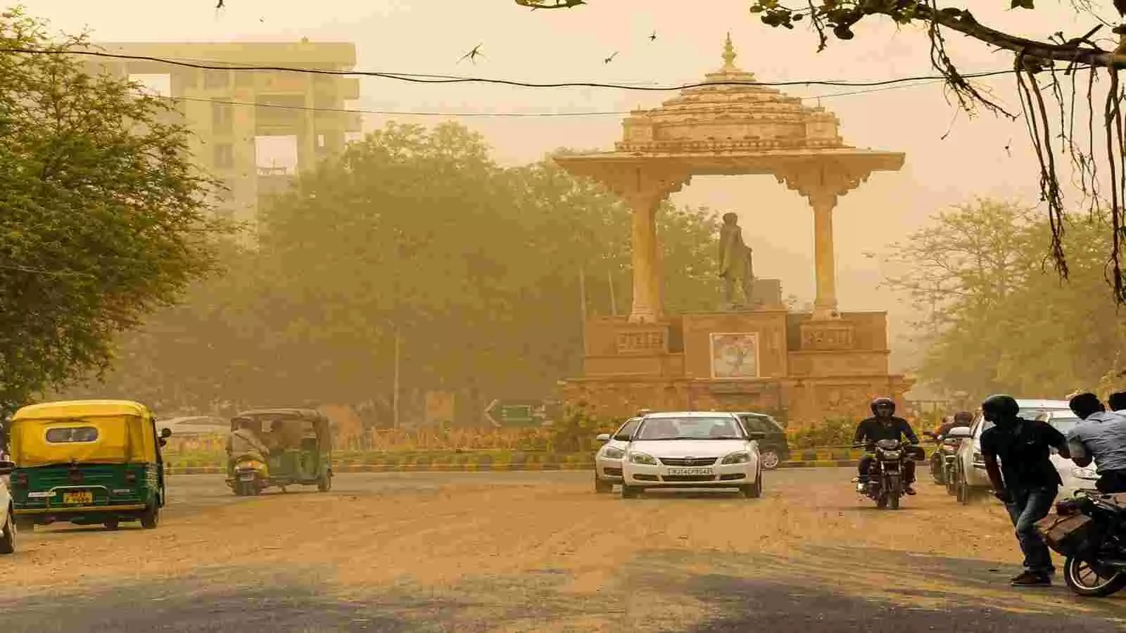 धूल के गुबार के बीच सड़क पर चलती कारें मोटरसाइकिलें और पृष्ठभूमि में एक स्मारक ढांचा। धूल के गुबार के बीच सड़क पर चलती कारें मोटरसाइकिलें और पृष्ठभूमि में एक स्मारक ढांचा।