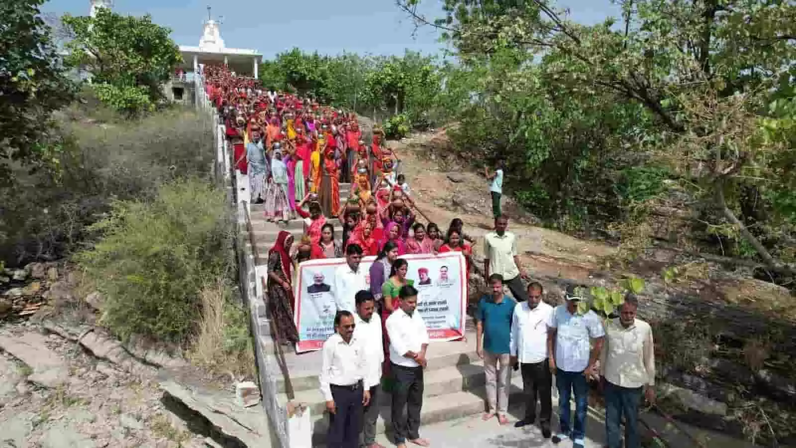 आमेट के आडावाला तालाब की सीढ़ियों पर कलश यात्रा निकालतीं महिलाएं और खड़े प्रशासनिक अधिकारी।