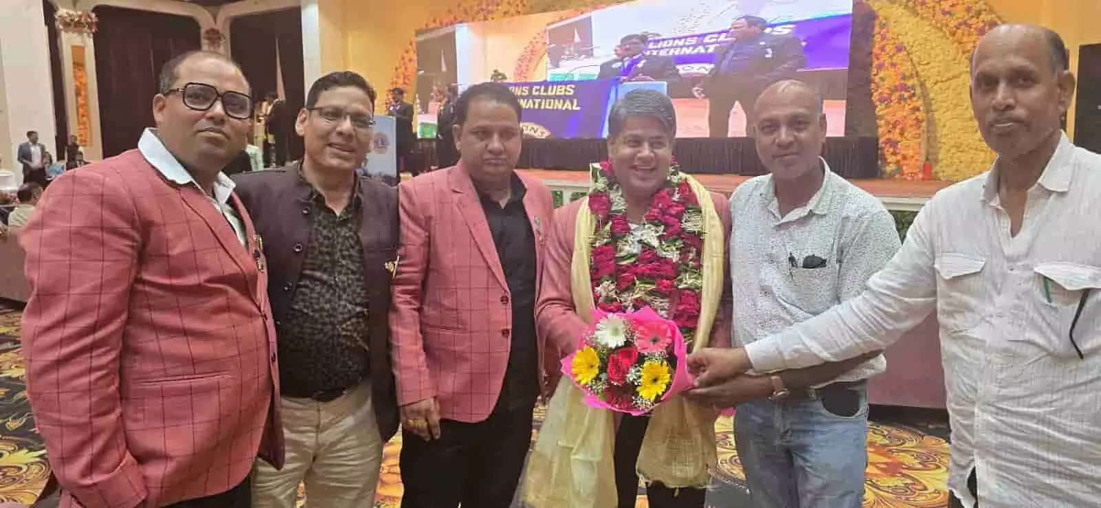 इंदौर में आयोजित लायंस इंटरनेशनल उर्विश कन्वेंशन 2026 के मंच पर फूलों का गुलदस्ता और माला पहने खड़े पुरस्कार विजेता पदाधिकारी।