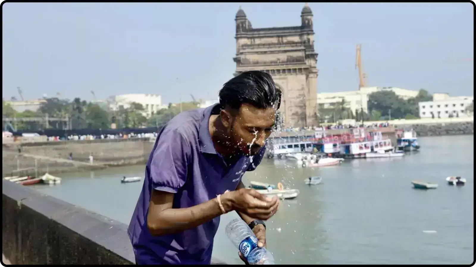 गेटवे ऑफ इंडिया के सामने खड़ा एक व्यक्ति अपने चेहरे पर पानी की बोतल से पानी छिड़क रहा है। गेटवे ऑफ इंडिया के सामने खड़ा एक व्यक्ति अपने चेहरे पर पानी की बोतल से पानी छिड़क रहा है।