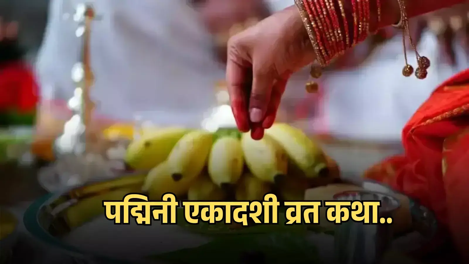 पूजा की थाली में रखे केले के फल पर सिंदूर लगे हाथ से अक्षत चढ़ाती हुई एक महिला। पूजा की थाली में रखे केले के फल पर सिंदूर लगे हाथ से अक्षत चढ़ाती हुई एक महिला।