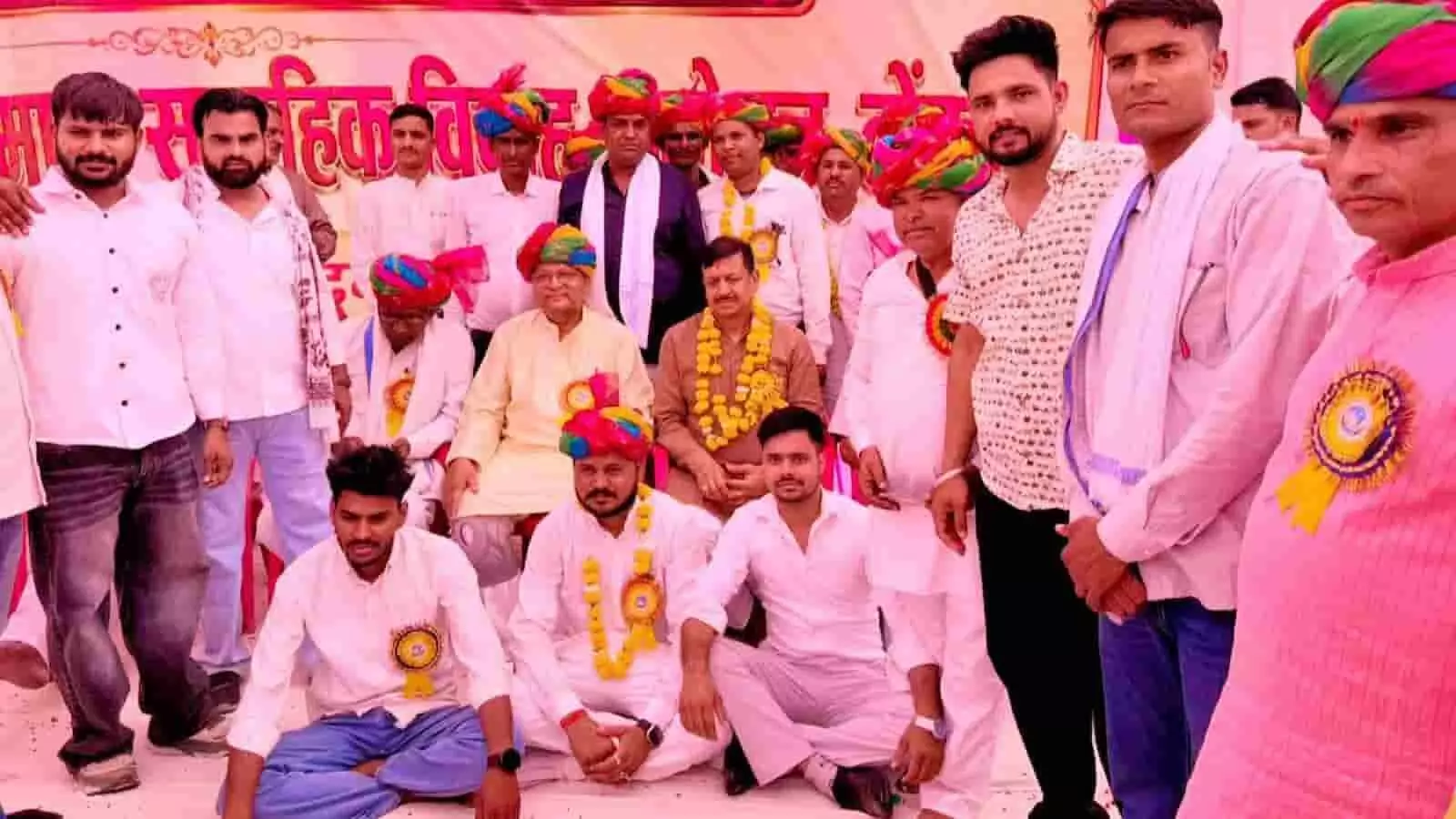 सामूहिक विवाह सम्मेलन के मंच पर साफा पहने अतिथि और समाज के लोग बैठे हुए। सामूहिक विवाह सम्मेलन के मंच पर साफा पहने अतिथि और समाज के लोग बैठे हुए।