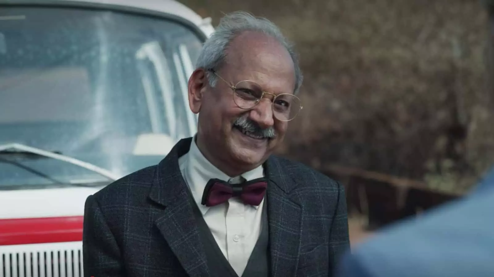 फिल्म के एक दृश्य में चश्मा और बो-टाई पहने मुस्कुराते हुए दिवंगत अभिनेता रमाकांत दायमा। फिल्म के एक दृश्य में चश्मा और बो-टाई पहने मुस्कुराते हुए दिवंगत अभिनेता रमाकांत दायमा।