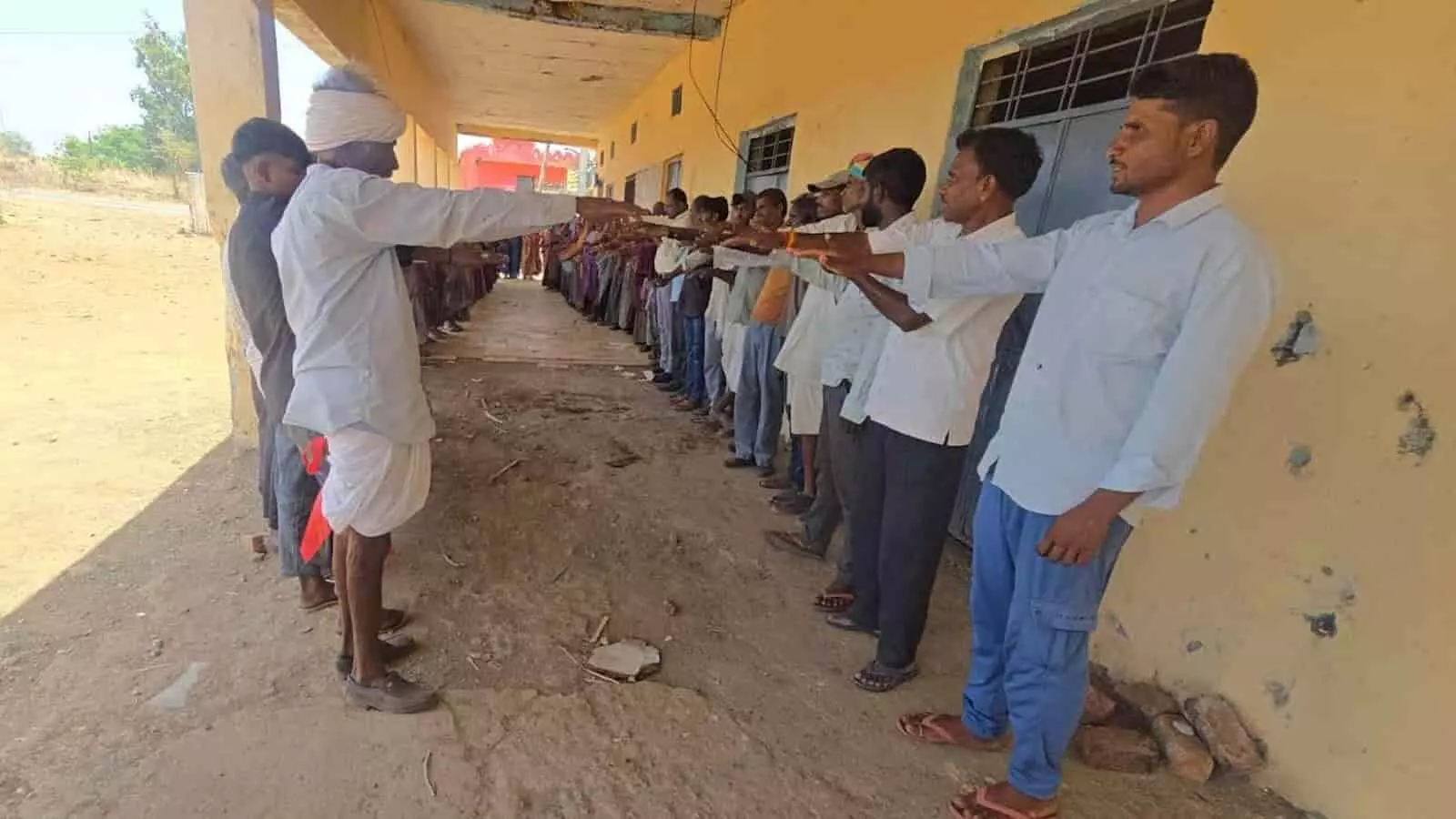 प्रतापगढ़ में सरकारी इमारत के बाहर कतार में खड़े होकर जल संरक्षण की शपथ लेते ग्रामीण पुरुष। प्रतापगढ़ में सरकारी इमारत के बाहर कतार में खड़े होकर जल संरक्षण की शपथ लेते ग्रामीण पुरुष।
