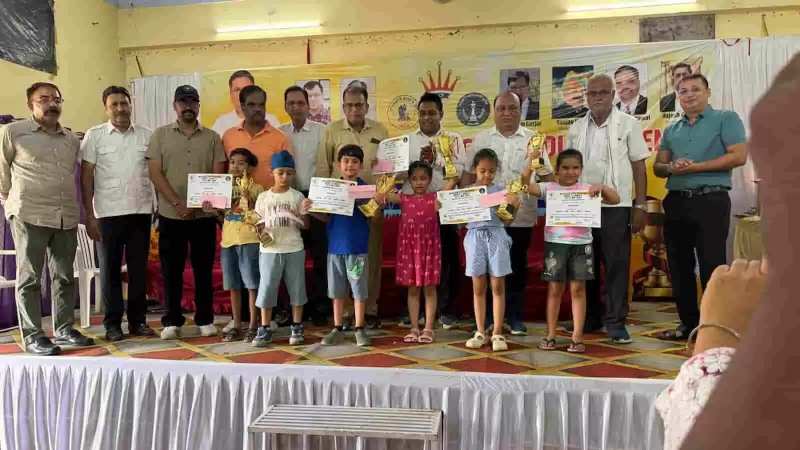 झालावाड़ में राज्य स्तरीय अंडर-7 शतरंज प्रतियोगिता के समापन समारोह में मंच पर ट्रॉफी और प्रमाण पत्र के साथ खड़े विजेता बच्चे और अतिथि। झालावाड़ में राज्य स्तरीय अंडर-7 शतरंज प्रतियोगिता के समापन समारोह में मंच पर ट्रॉफी और प्रमाण पत्र के साथ खड़े विजेता बच्चे और अतिथि।