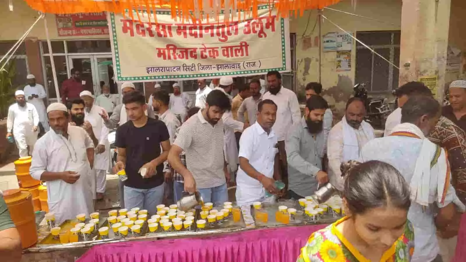 झालरापाटन के बस स्टैंड पर टेंट के नीचे राहगीरों को ठंडा शर्बत पिलाते हुए लोग। झालरापाटन के बस स्टैंड पर टेंट के नीचे राहगीरों को ठंडा शर्बत पिलाते हुए लोग।