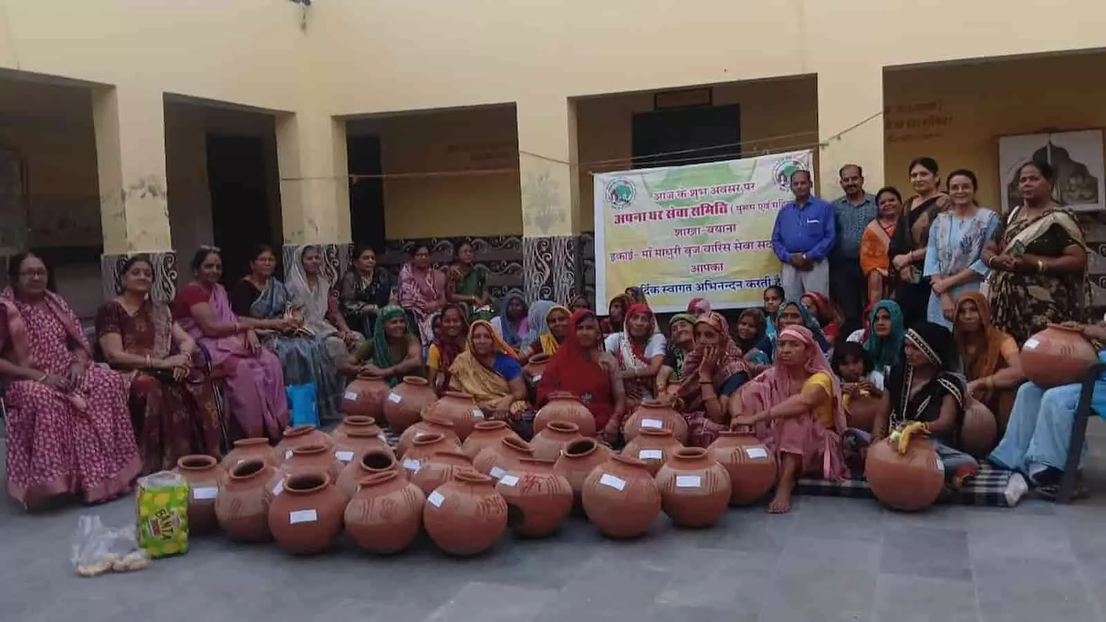बयाना के ब्रह्मबाद में क्षतिग्रस्त पेयजल पाइपलाइन के कारण सड़क पर फैले पानी और कीचड़ के बीच से गुजरते स्थानीय ग्रामीण।