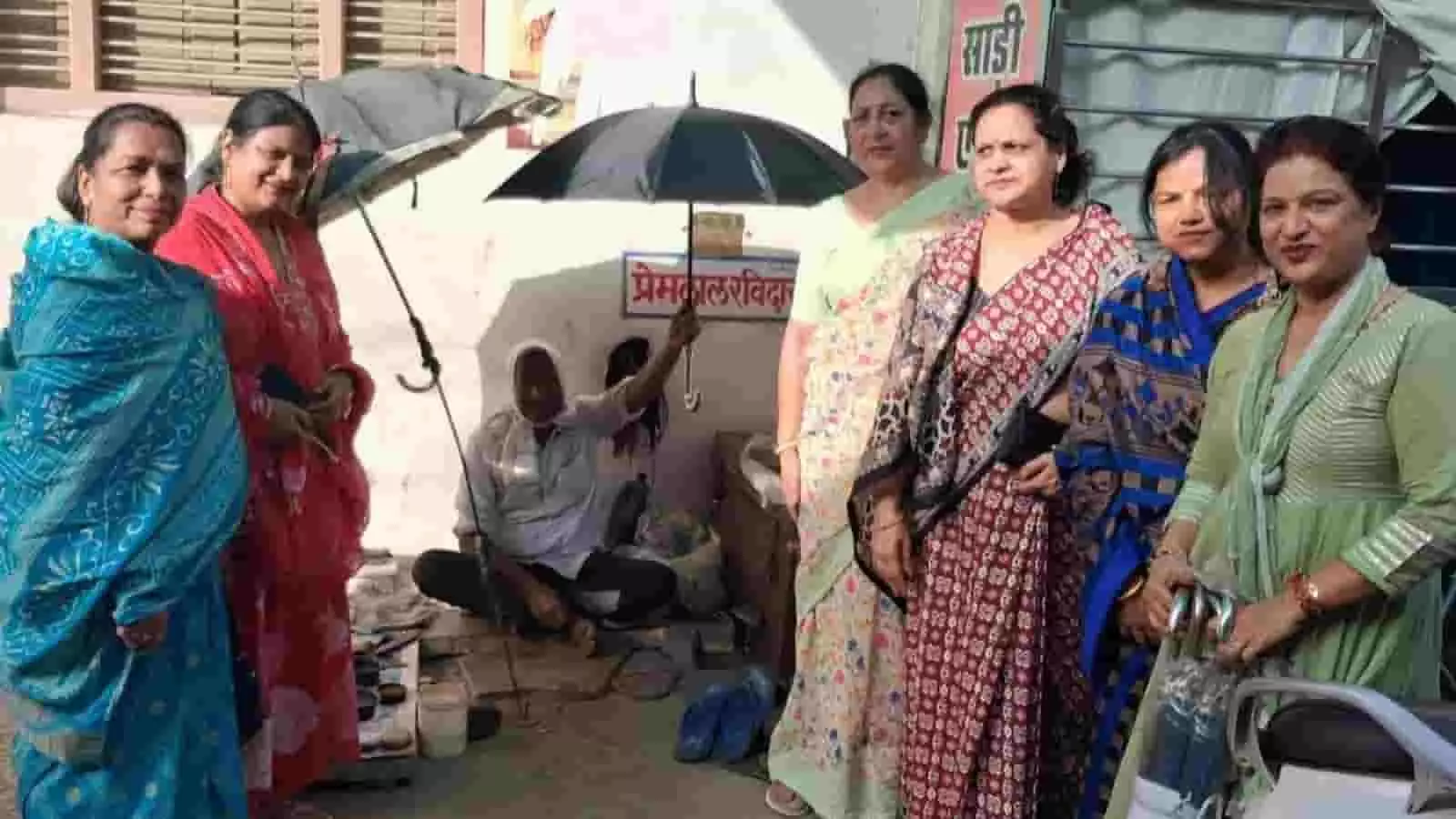 बारां में अखिल भारतीय अग्रवाल महिला जिला संगठन की सदस्य एक फुटपाथ कर्मी को छाता देते हुए।