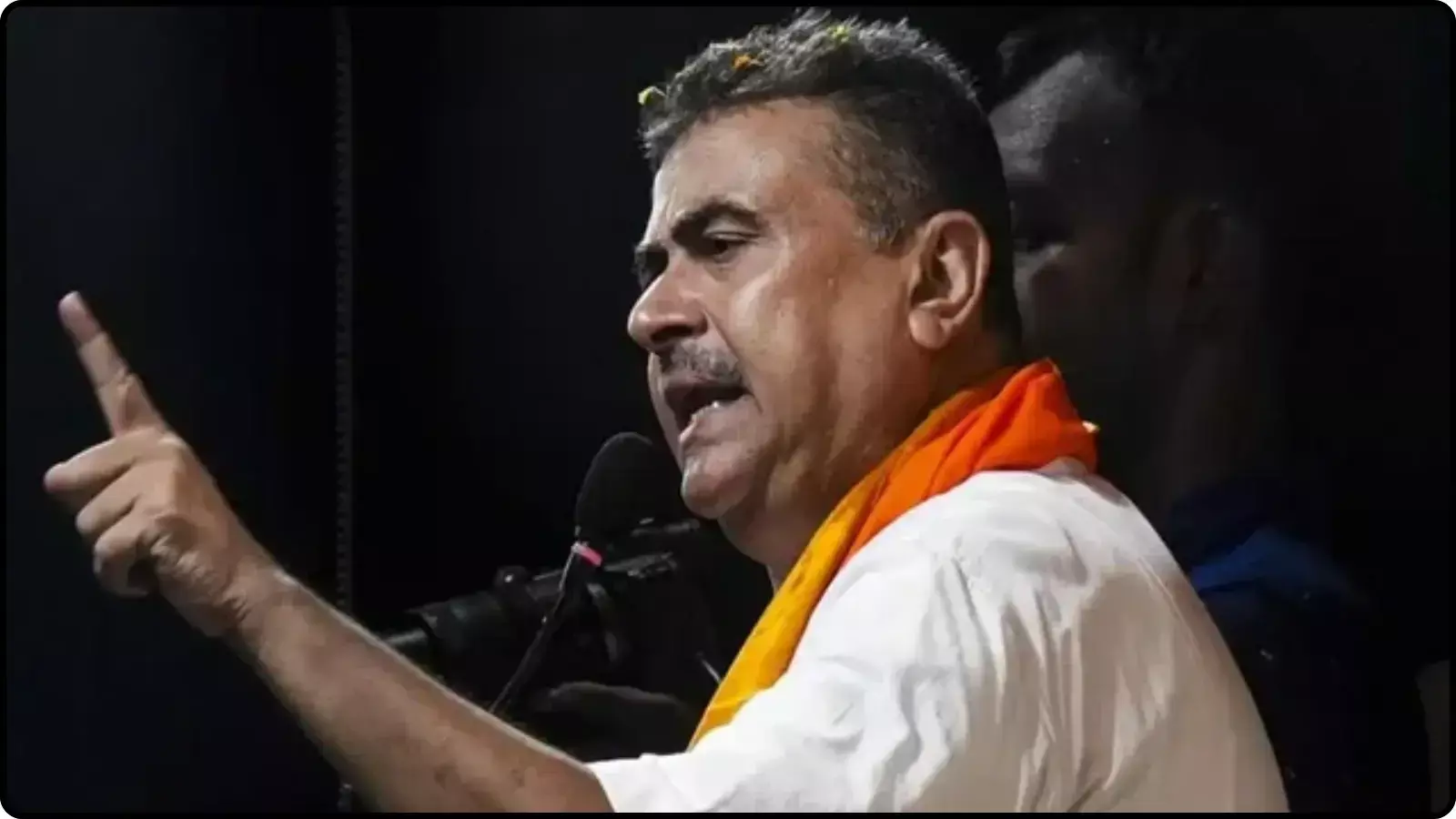 मंच पर माइक के सामने बोलते हुए और उंगली से इशारा करते हुए एक राजनीतिक नेता। मंच पर माइक के सामने बोलते हुए और उंगली से इशारा करते हुए एक राजनीतिक नेता।