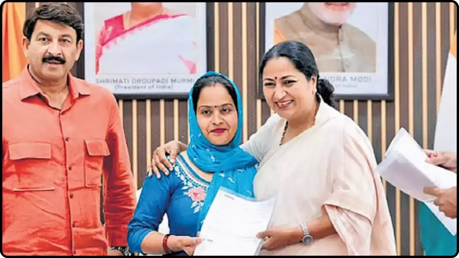 कार्यालय के भीतर दस्तावेज हाथ में लिए हुए खड़े पुरुष और दो महिलाएं।