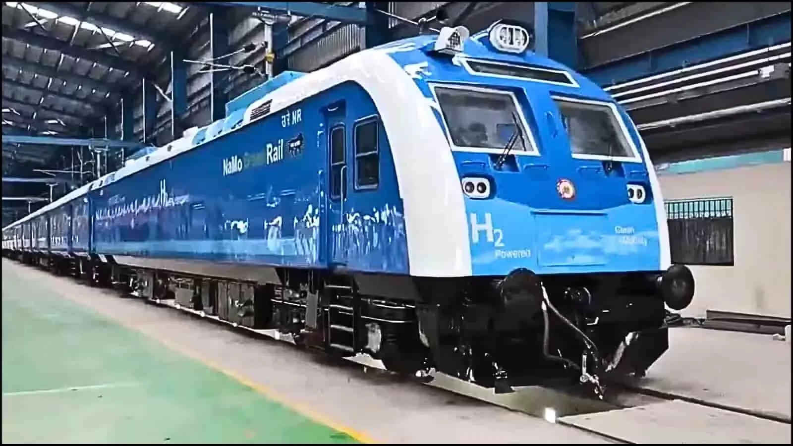 नीले और सफेद रंग का भारतीय रेलवे का नया हाइड्रोजन ट्रेन इंजन पटरियों पर खड़ा है।