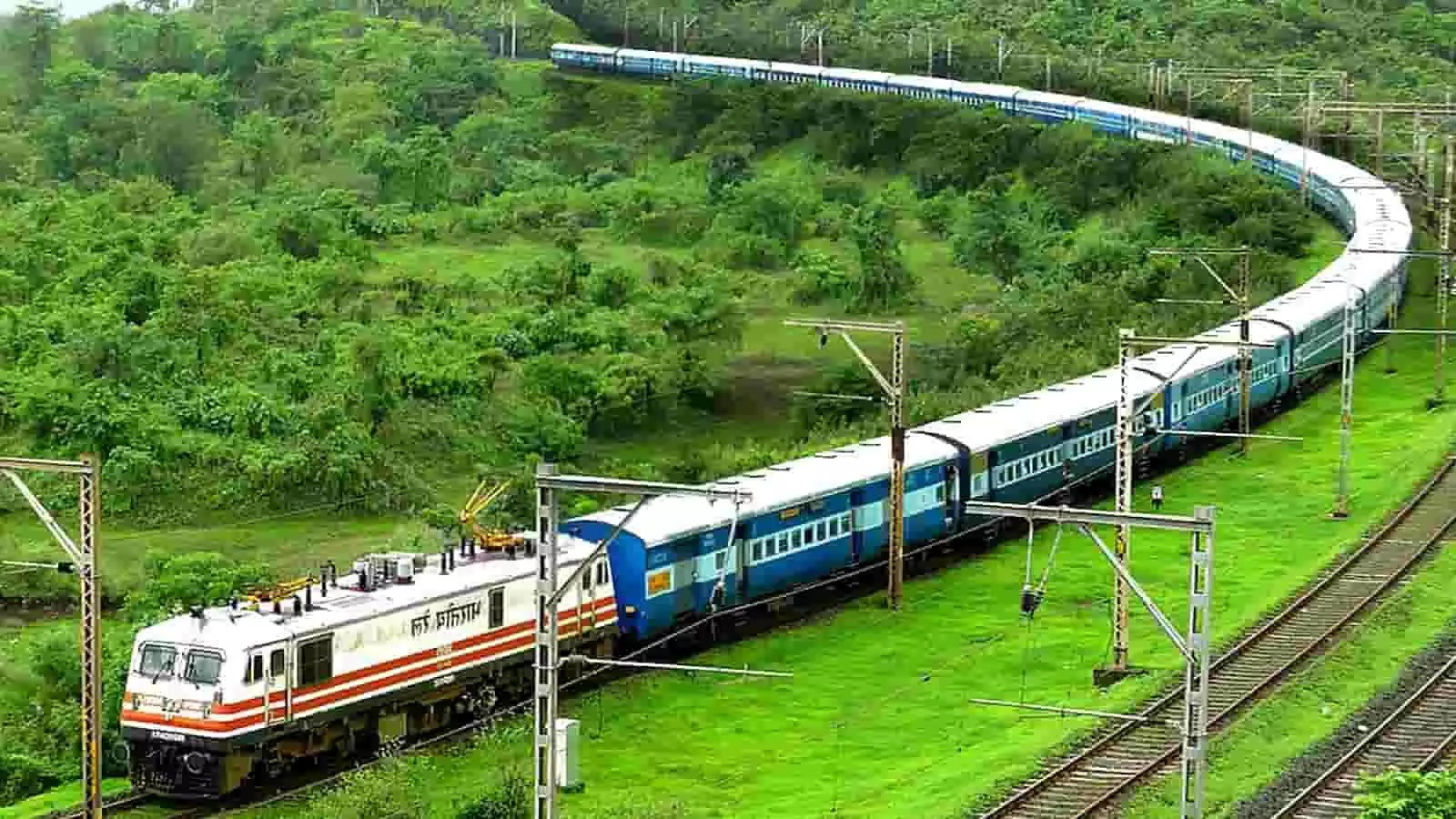हरी-भरी पहाड़ियों के बीच घुमावदार पटरी पर दौड़ती हुई भारतीय रेलवे की एक्सप्रेस ट्रेन। हरी-भरी पहाड़ियों के बीच घुमावदार पटरी पर दौड़ती हुई भारतीय रेलवे की एक्सप्रेस ट्रेन।