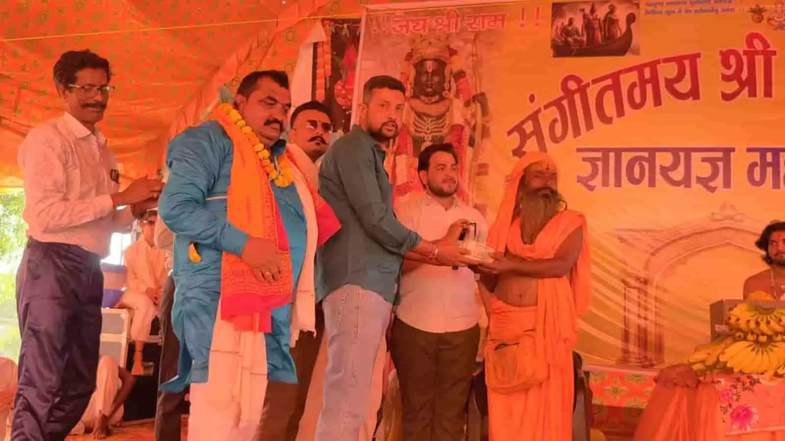 करौली में धार्मिक आयोजन के मंच पर संत को सहयोग राशि भेंट करते लोग करौली में धार्मिक आयोजन के मंच पर संत को सहयोग राशि भेंट करते लोग