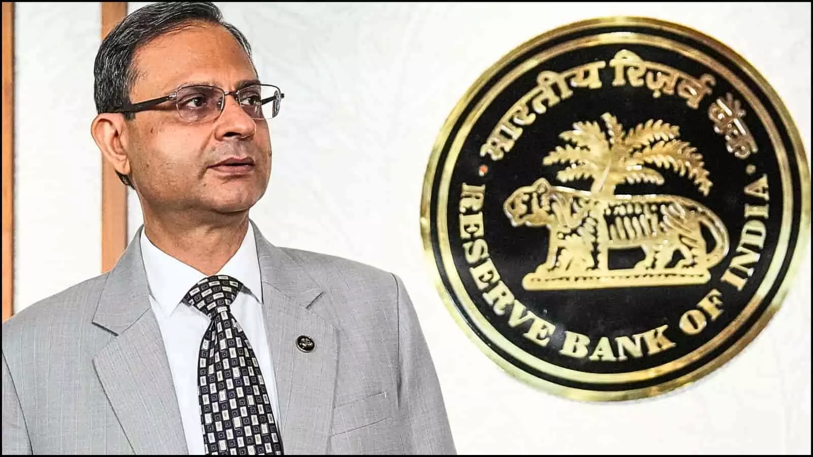 दीवार पर लगा भारतीय रिजर्व बैंक का लोगो और पास खड़ा एक अधिकारी आर्थिक रिपोर्ट के संदर्भ में दिख रहा है।