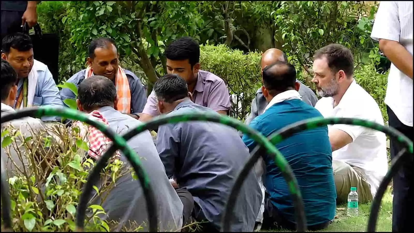 पार्क में जमीन पर बैठकर ऑटो चालकों से बातचीत करते राहुल गांधी दिल्ली में जनसंपर्क के दौरान।