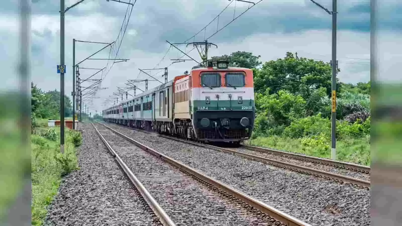 पटरियों पर दौड़ती हुई भारतीय रेलवे की एक पैसेंजर ट्रेन और ओवरहेड बिजली के तार। पटरियों पर दौड़ती हुई भारतीय रेलवे की एक पैसेंजर ट्रेन और ओवरहेड बिजली के तार।
