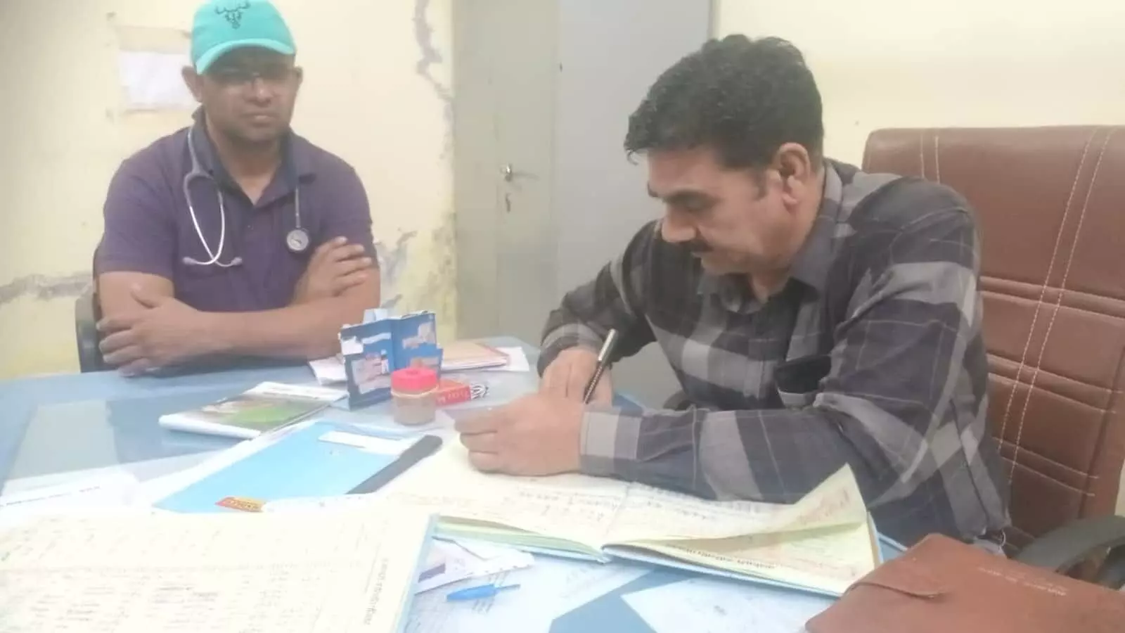 सपोटरा उप जिला अस्पताल के कार्यालय में रजिस्टर की जांच करते सीएमएचओ डॉ. सतीश चंद मीना और चिकित्साकर्मी।