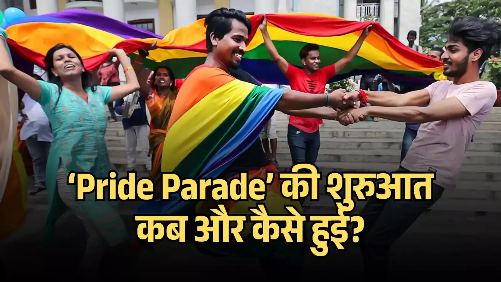 सड़क पर बड़ा इंद्रधनुषी झंडा उठाकर चलते और मुस्कुराते हुए प्रदर्शनकारी।