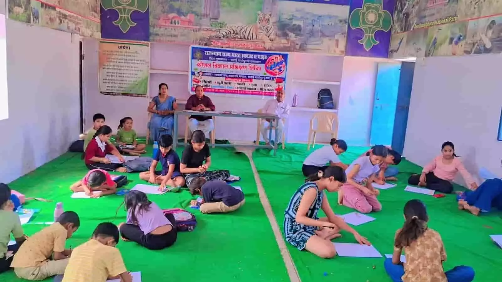 सवाई माधोपुर के स्काउट गाइड शिविर में दरी पर बैठकर चित्रकारी प्रतियोगिता में भाग लेते बच्चे और बैठे अधिकारी। सवाई माधोपुर के स्काउट गाइड शिविर में दरी पर बैठकर चित्रकारी प्रतियोगिता में भाग लेते बच्चे और बैठे अधिकारी।