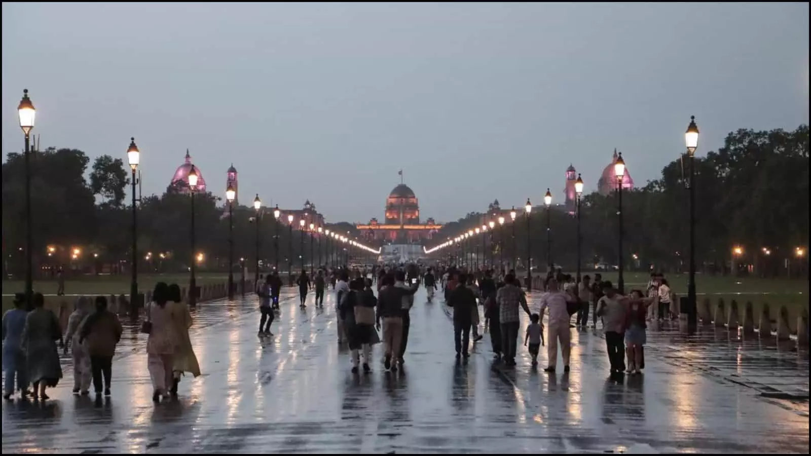 बारिश से गीली सड़क पर चलते हुए लोग राष्ट्रपति भवन के सामने कर्तव्य पथ दिल्ली में मौसम बदलने के बाद।