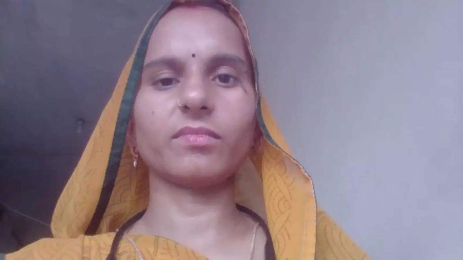 पीले और हरे रंग की साड़ी पहने ग्रामीण महिला रीना कुमारी सैनी डीग जिले में बैंक सखी के संदर्भ में दिख रही हैं।