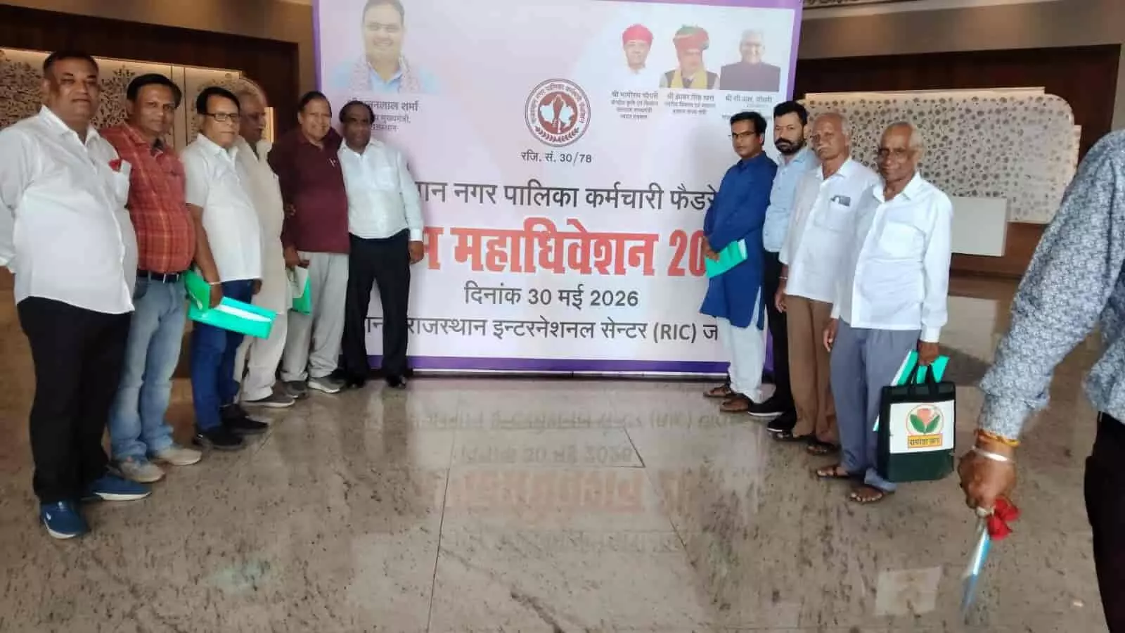 राजस्थान इंटरनेशनल सेंटर में बैनर के सामने खड़े राजस्थान नगर पालिका कर्मचारी फेडरेशन के पदाधिकारी