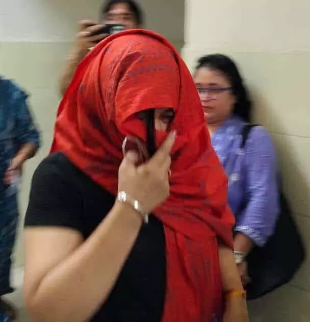 चित्तौड़गढ़ ईएसआईसी कार्यालय में घूस लेते पकड़ी गई आरोपी महिला अधिकारी संदीपा बोहरा लाल दुपट्टे से मुंह ढके खड़ी दिखाई दे रही हैं।