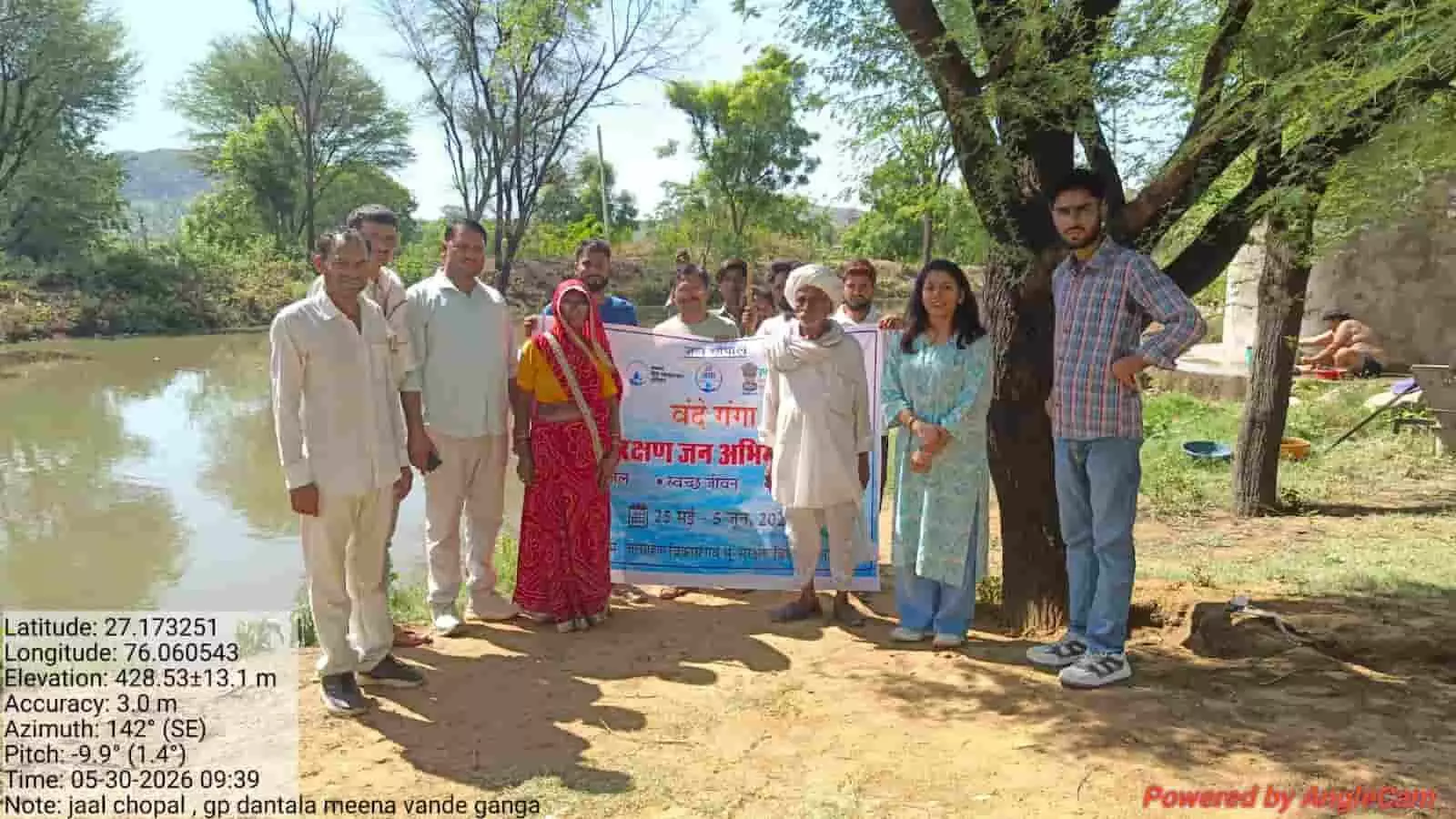 दांतला मीणा ग्राम पंचायत में जल चौपाल के दौरान वंदे गंगा अभियान का बैनर पकड़े खड़े ग्रामीण अधिकारी।