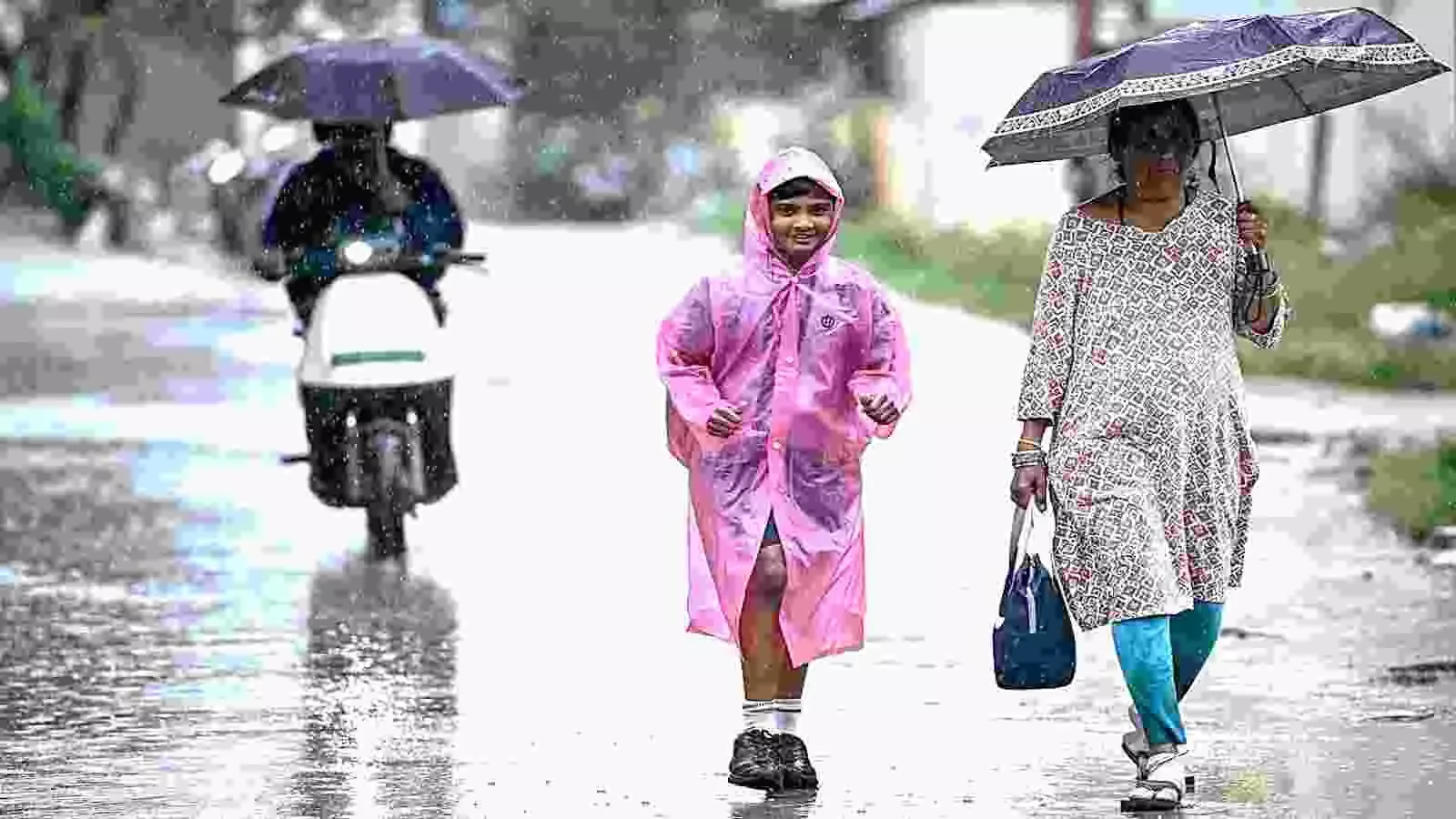 बारिश के दौरान सड़क पर छाता लेकर चलती महिला और रेनकोट पहने बच्चा दृश्यमान हैं। बारिश के दौरान सड़क पर छाता लेकर चलती महिला और रेनकोट पहने बच्चा दृश्यमान हैं।