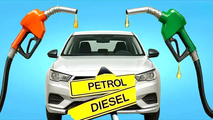 सफेद कार के सामने पेट्रोल और डीजल लिखे पीले बोर्ड के साथ तेल भरने वाले दो नोजल दिखाई दे रहे हैं। सफेद कार के सामने पेट्रोल और डीजल लिखे पीले बोर्ड के साथ तेल भरने वाले दो नोजल दिखाई दे रहे हैं।
