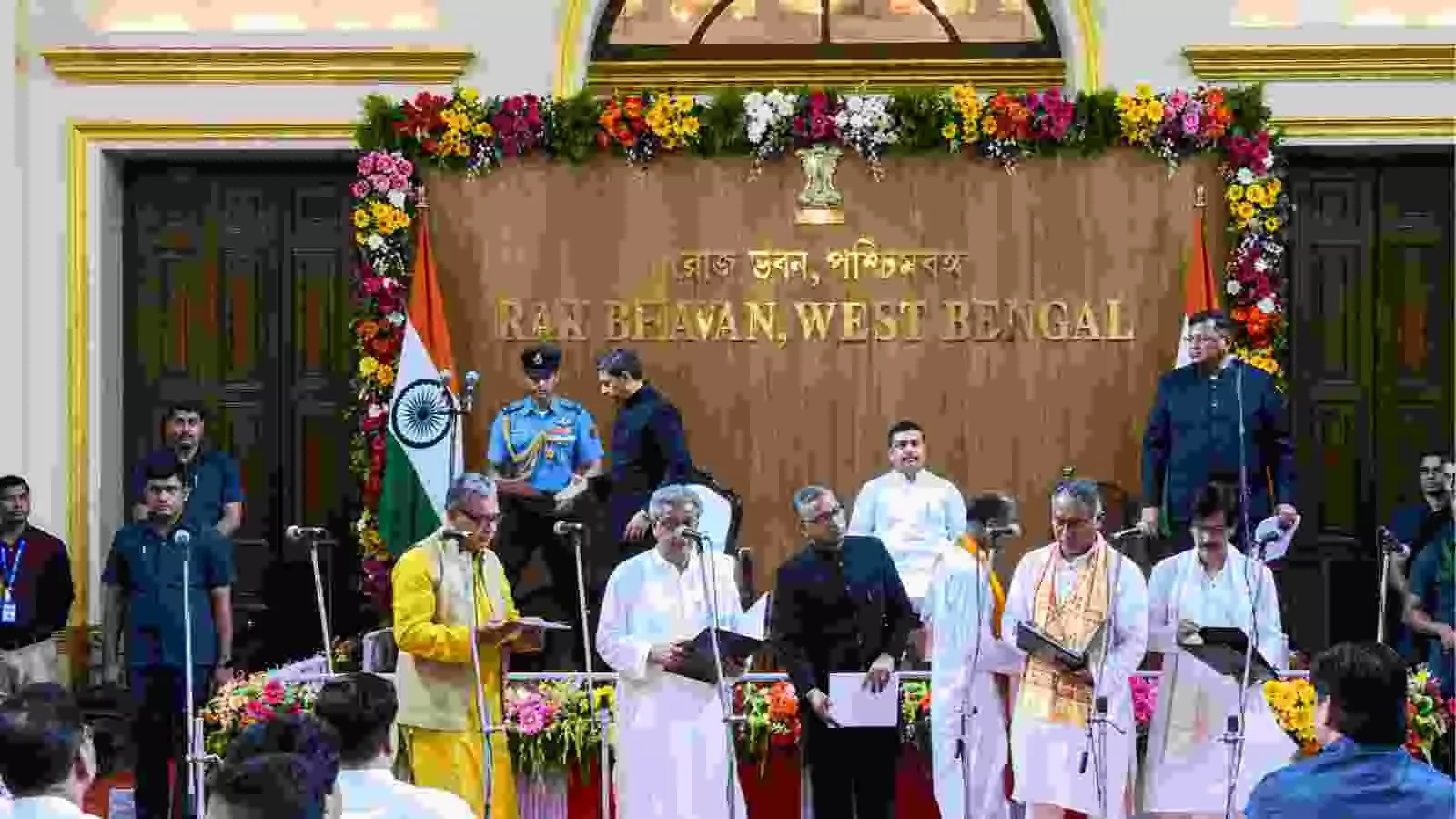 कोलकाता के लोक भवन में मंच पर खड़े नवनियुक्त मंत्री शपथ पत्र पढ़ते हुए दिख रहे हैं। कोलकाता के लोक भवन में मंच पर खड़े नवनियुक्त मंत्री शपथ पत्र पढ़ते हुए दिख रहे हैं।