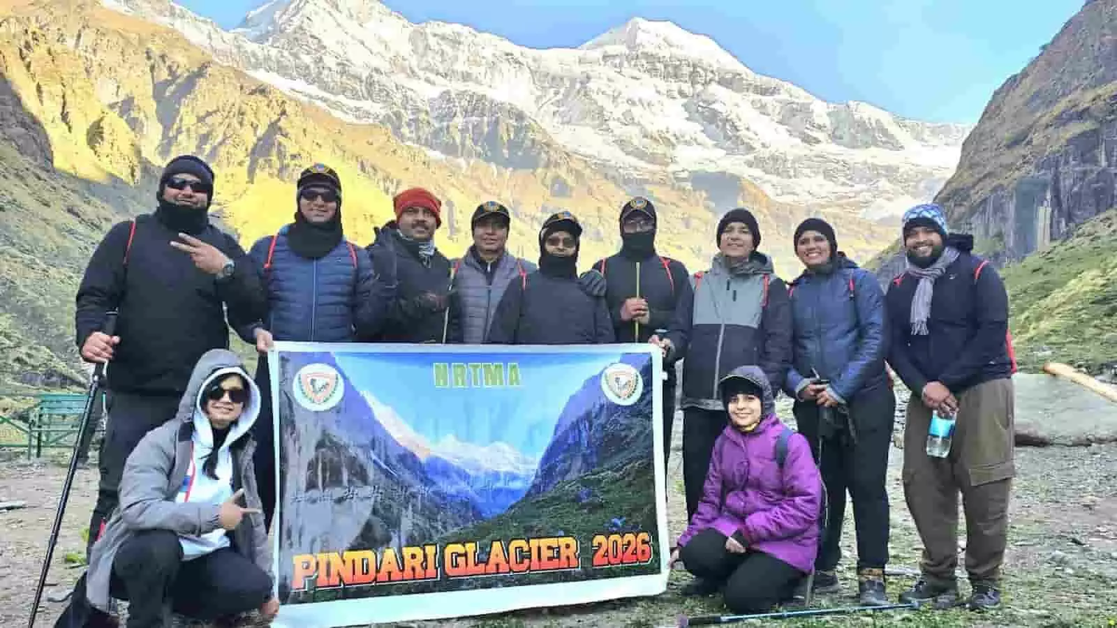 पिंडारी ग्लेशियर ट्रैकिंग अभियान के बैनर के साथ रेलवे कर्मचारी उत्तराखंड के पर्वतीय क्षेत्र में खड़े हैं। पिंडारी ग्लेशियर ट्रैकिंग अभियान के बैनर के साथ रेलवे कर्मचारी उत्तराखंड के पर्वतीय क्षेत्र में खड़े हैं।